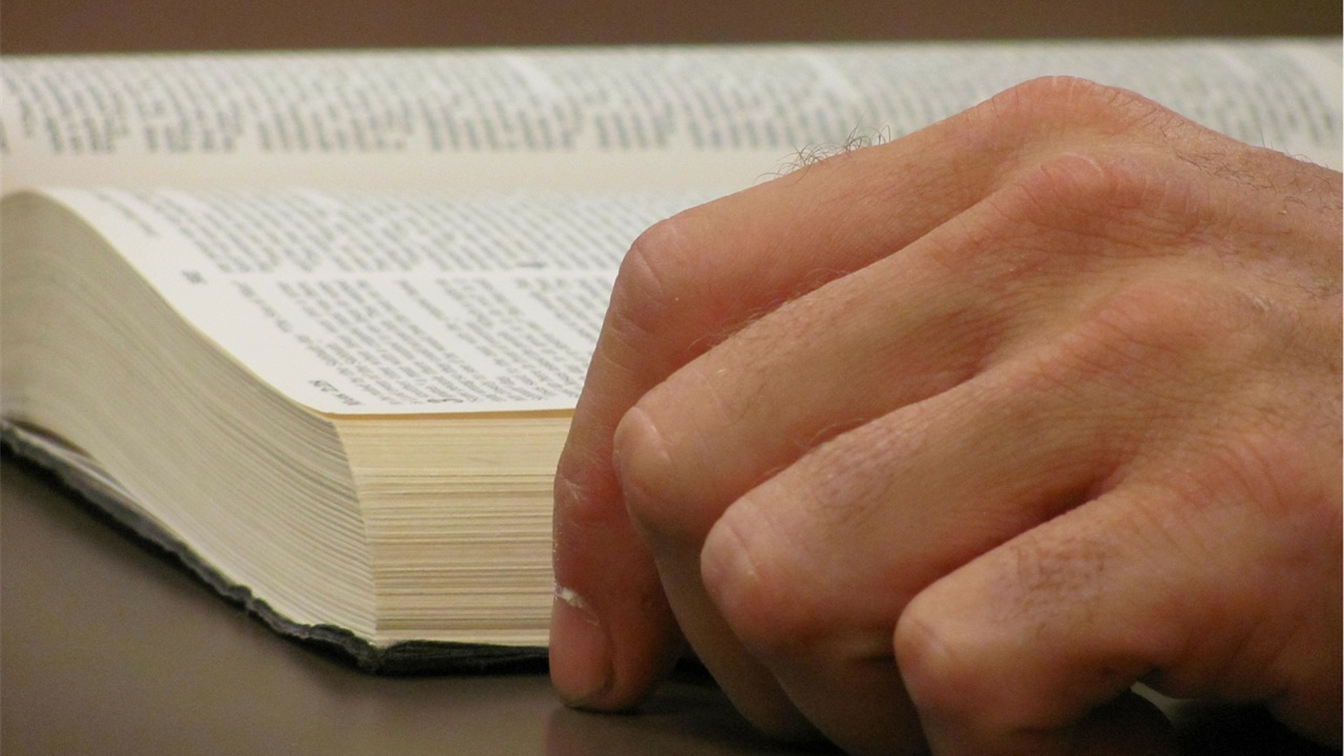 Mano sobre una Biblia abierta